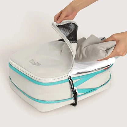 Mains qui rangent des vêtements dans un cube extensible ouvert